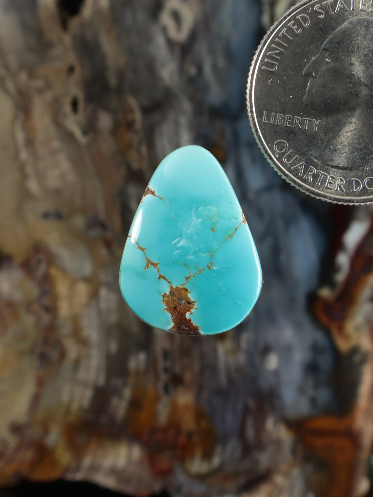 Turquoise cabochon gemstone in a teardrop shape with natural matrix veining