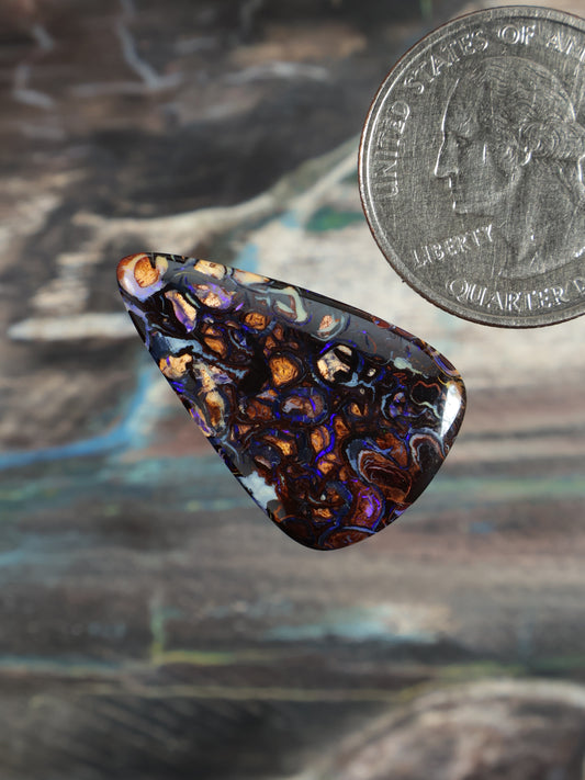 Boulder opal cabochon, iridescent blue-purple with orange flashes, angled triangular teardrop