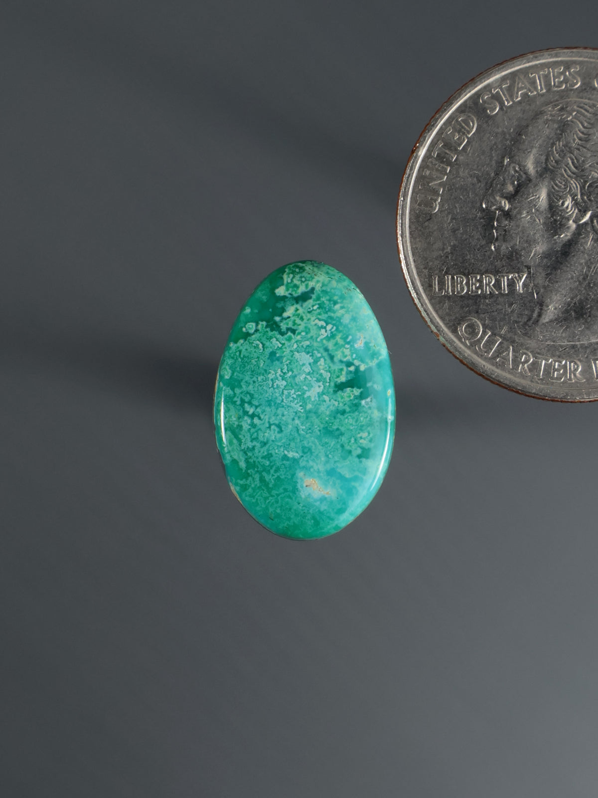 Oval green turquoise cabochon gemstone with polished surface