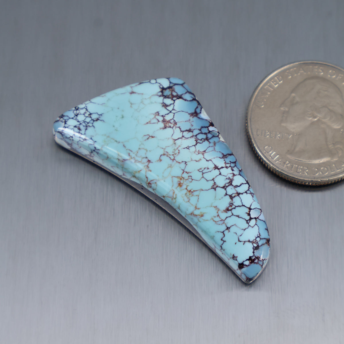 Turquoise cabochon with marbled webbing, shield/teardrop shape, smooth polished surface