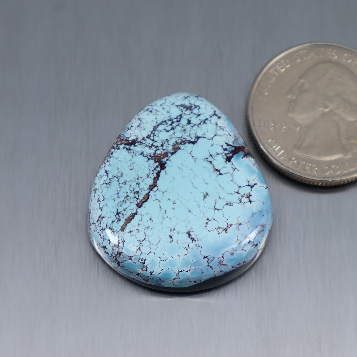 Blue turquoise teardrop cabochon with dark webbed matrix veins, polished, flat-back