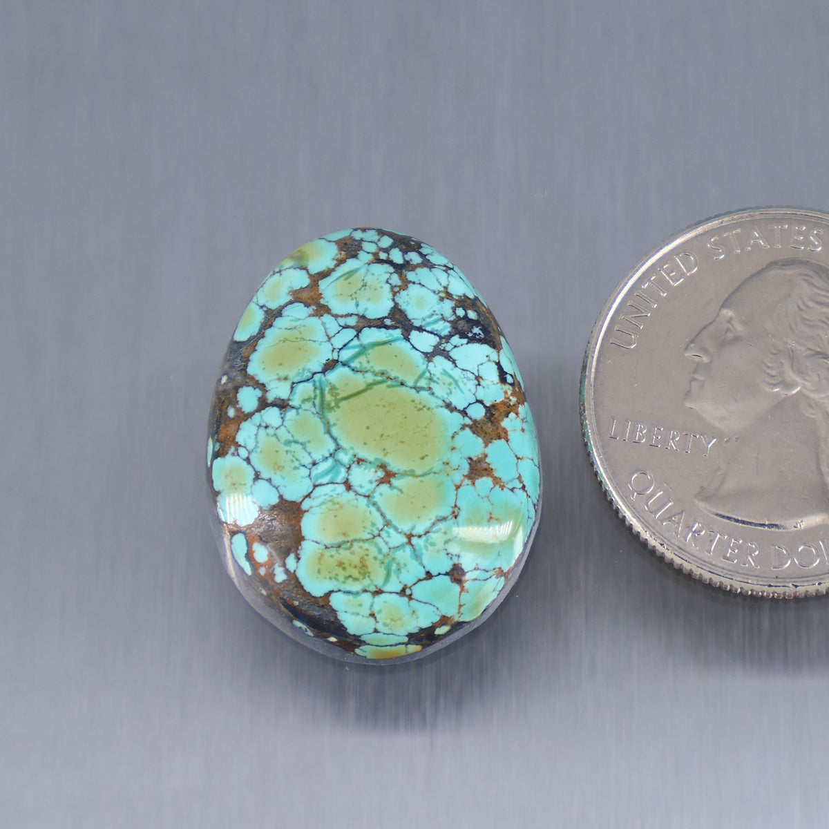 Skyhorse turquoise cabochon gemstone, oval blue-green with webbed matrix pattern