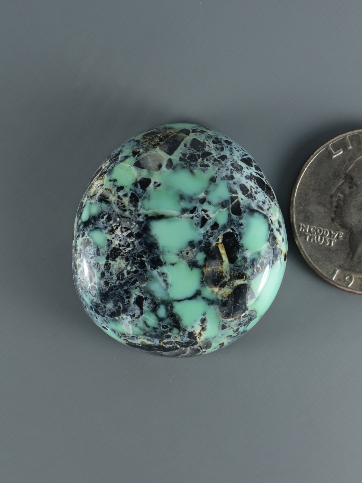 Prince Variscite cabochon, round mint-turquoise stone with black inclusions and patches