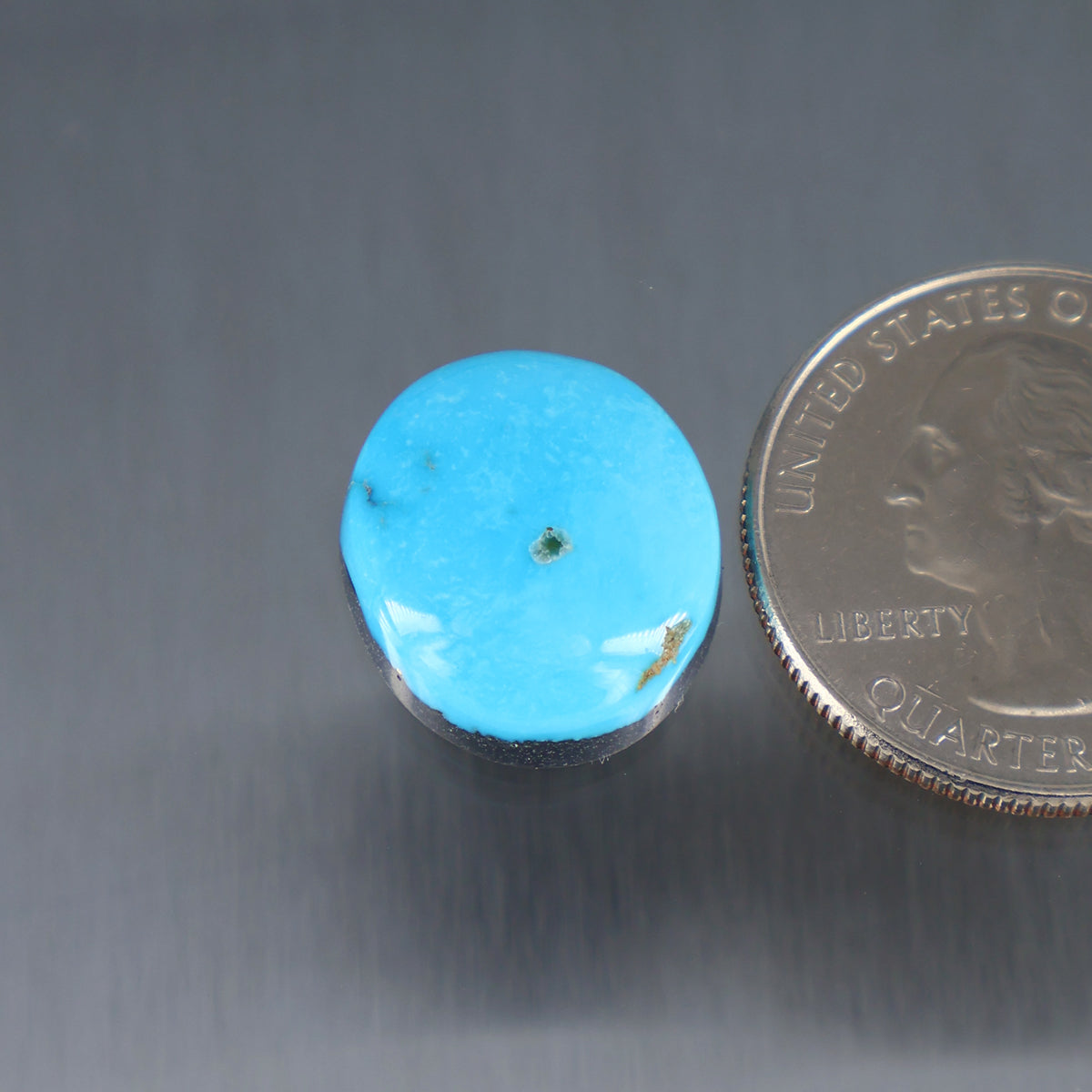 Round turquoise cabochon with small metal bezel, gemstone close-up