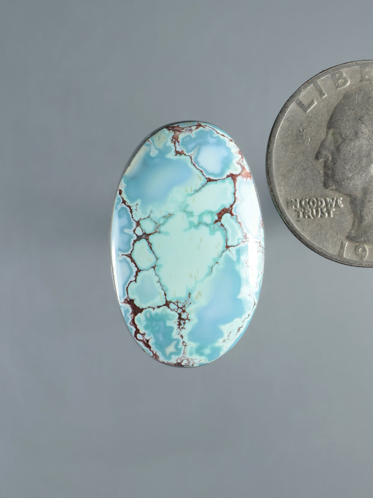 Oval turquoise gemstone cabochon with red matrix veining