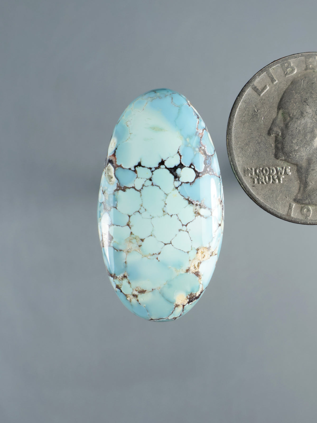 Oval turquoise cabochon gemstone with brown matrix veins