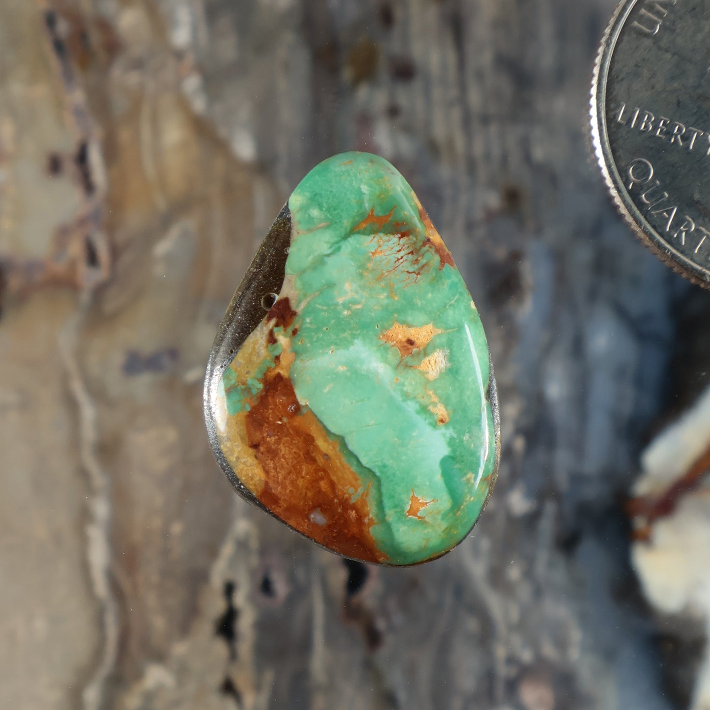 Royston turquoise cabochon with green teardrop shape and brown matrix.