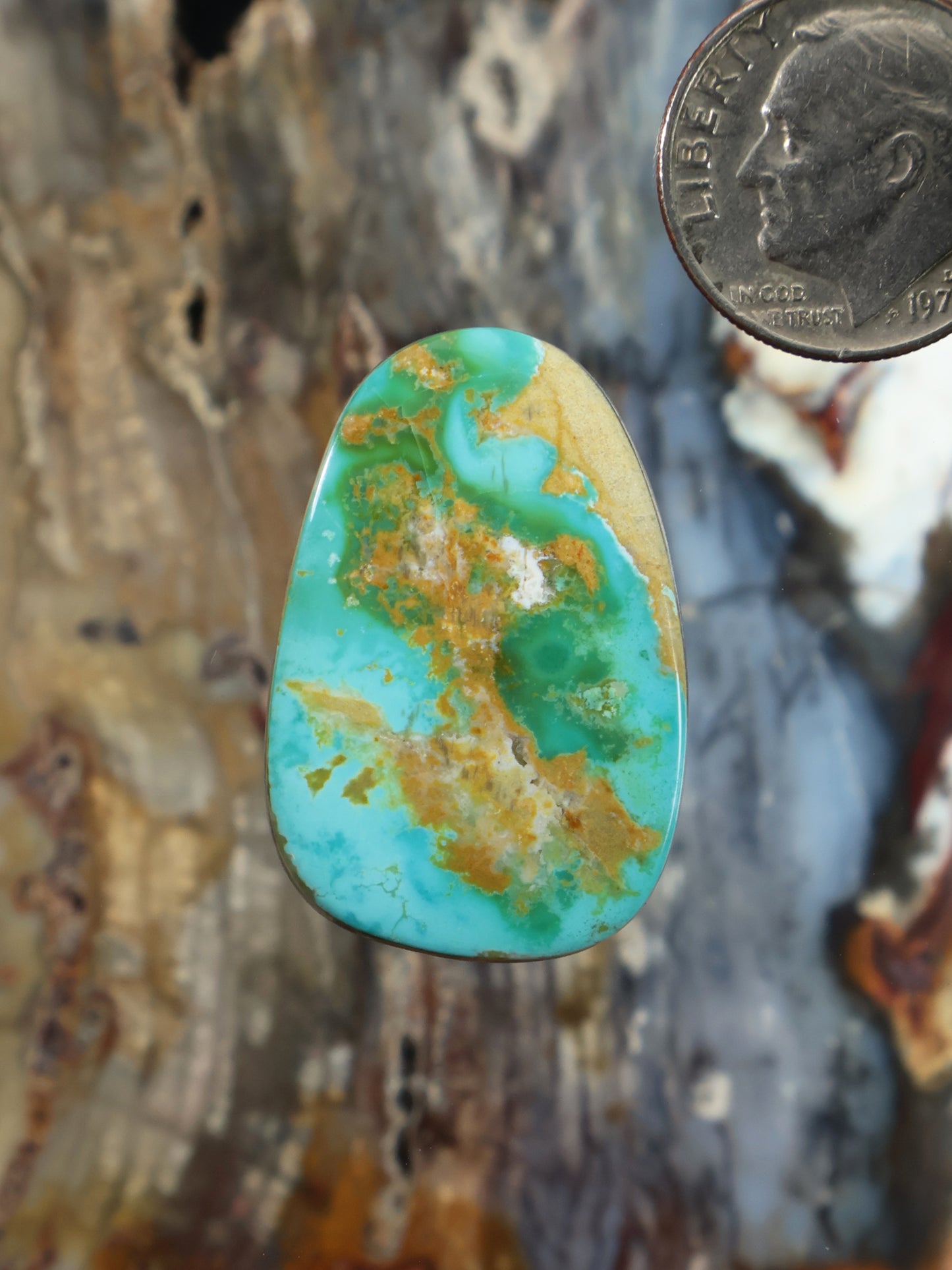 Oval turquoise cabochon gemstone with gold-brown matrix pattern