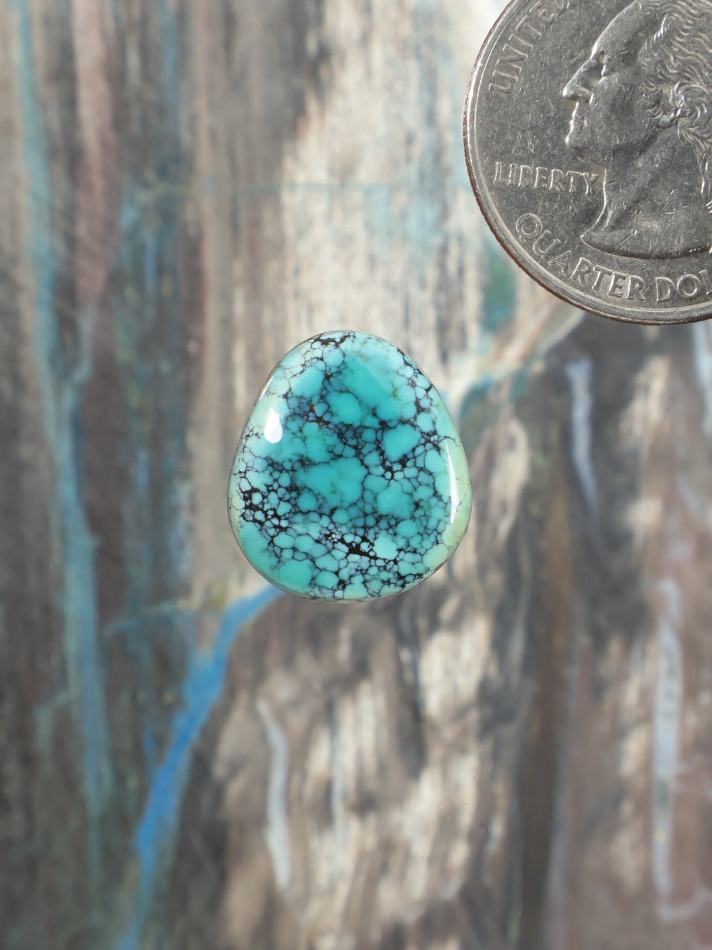Turquoise cabochon gemstone with teardrop shape and natural blue matrix pattern
