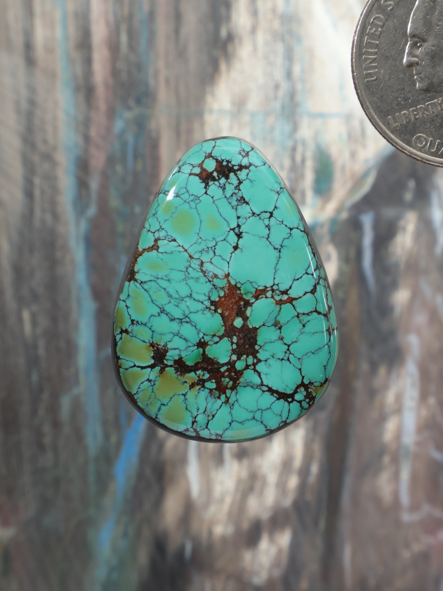 Turquoise cabochon gemstone with teardrop shape and webbed matrix pattern