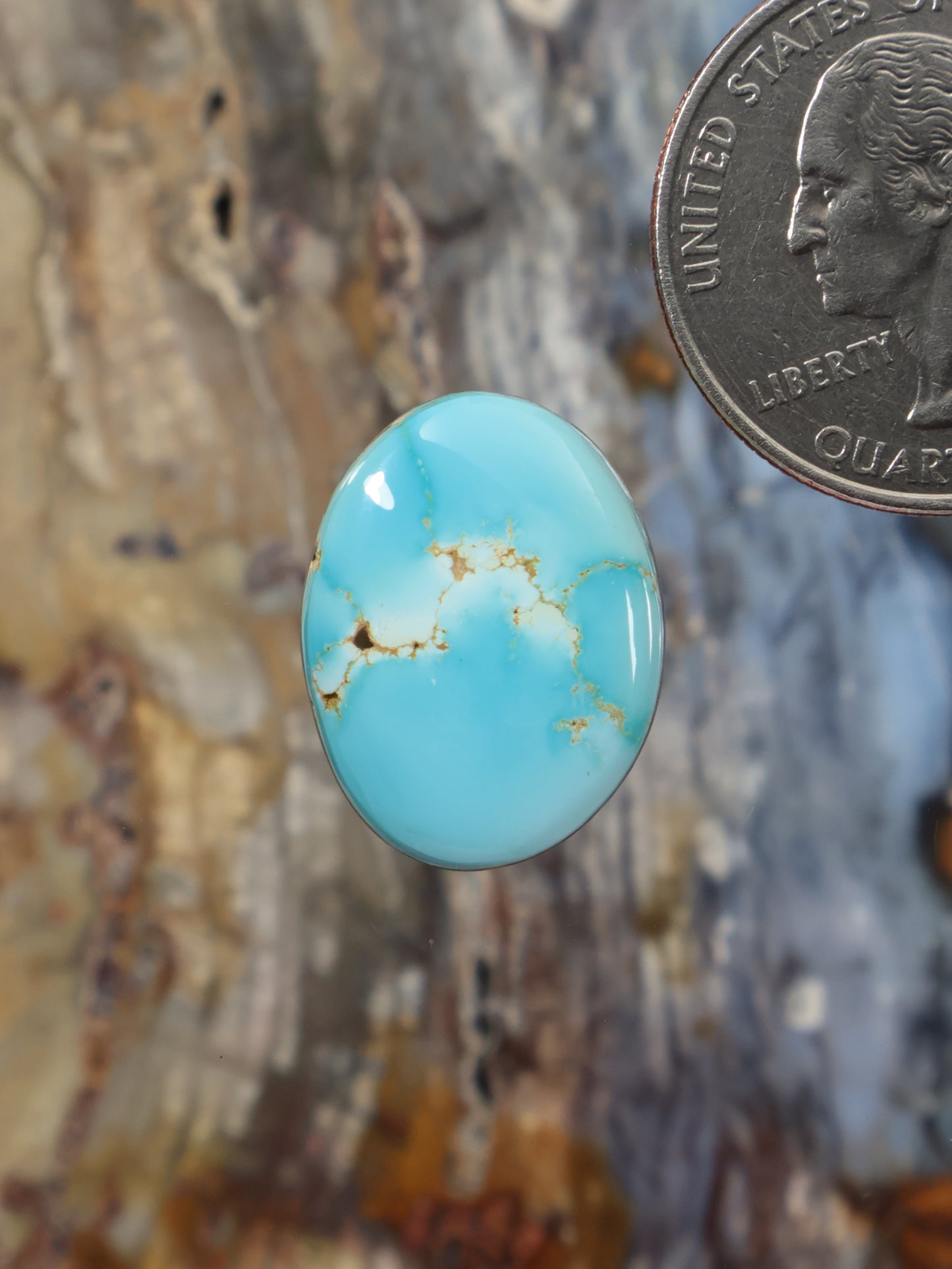 Light blue turquoise cabochon gemstone, oval with tan web-like matrix veining