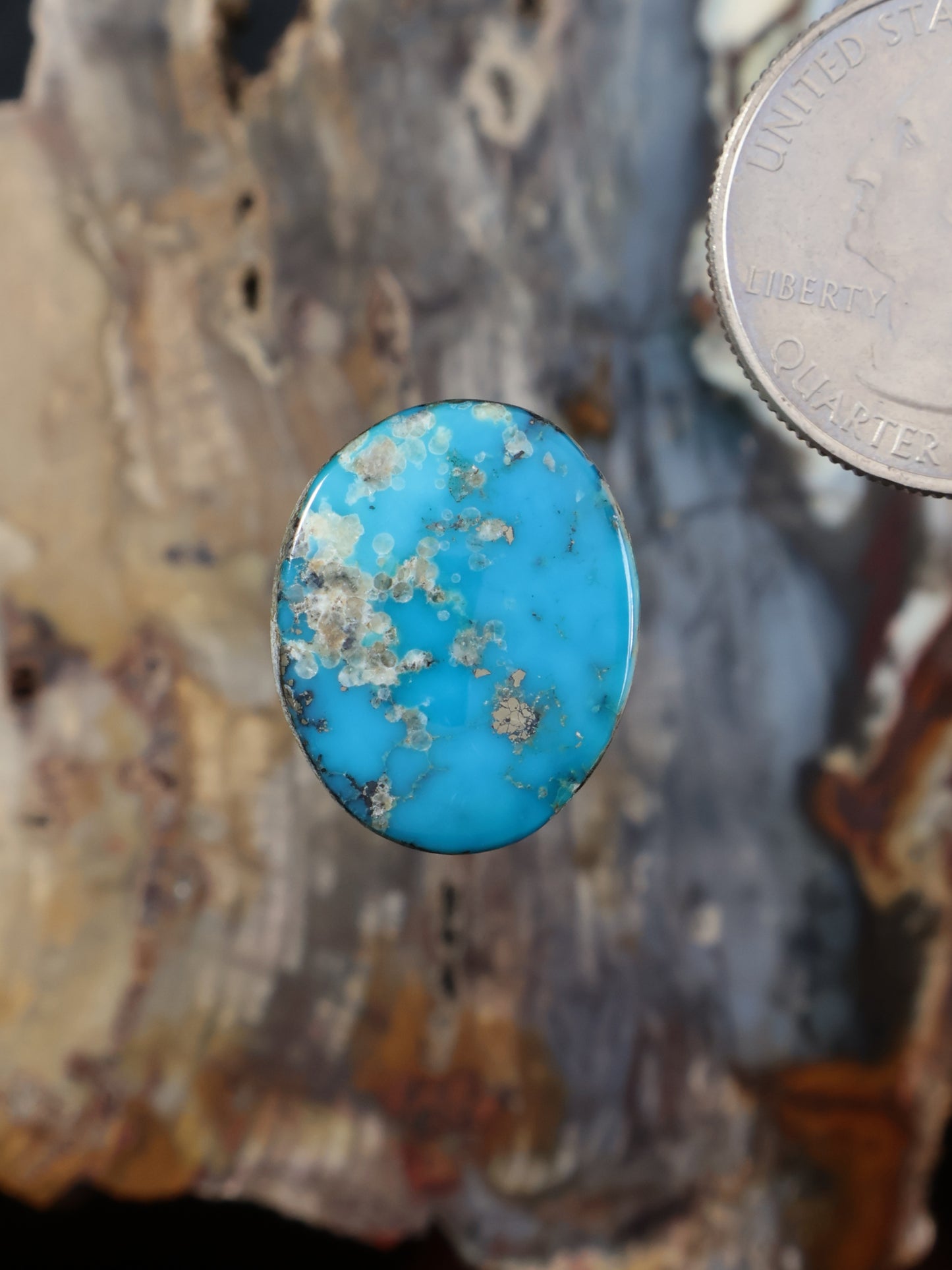 Turquoise blue cabochon gemstone with gold matrix speckles, oval shape