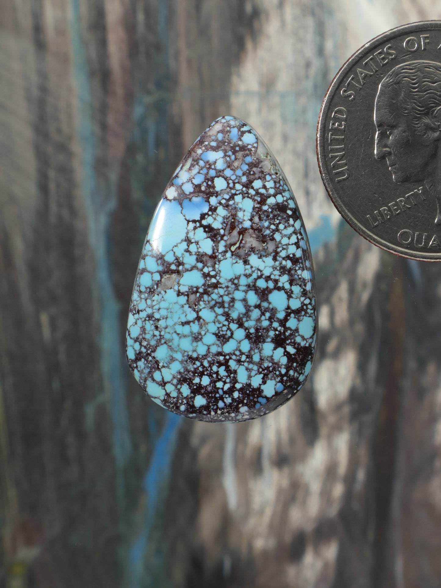 Turquoise teardrop cabochon with dark natural matrix and speckled pattern