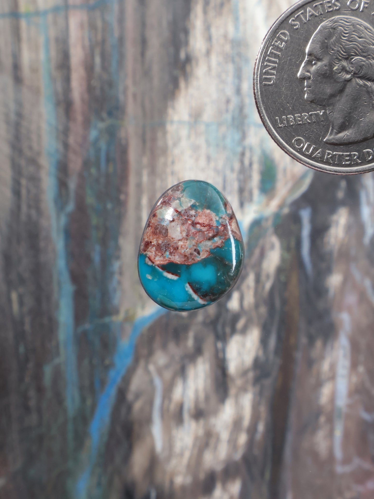 Oval turquoise cabochon with red-brown matrix inclusions, polished gemstone
