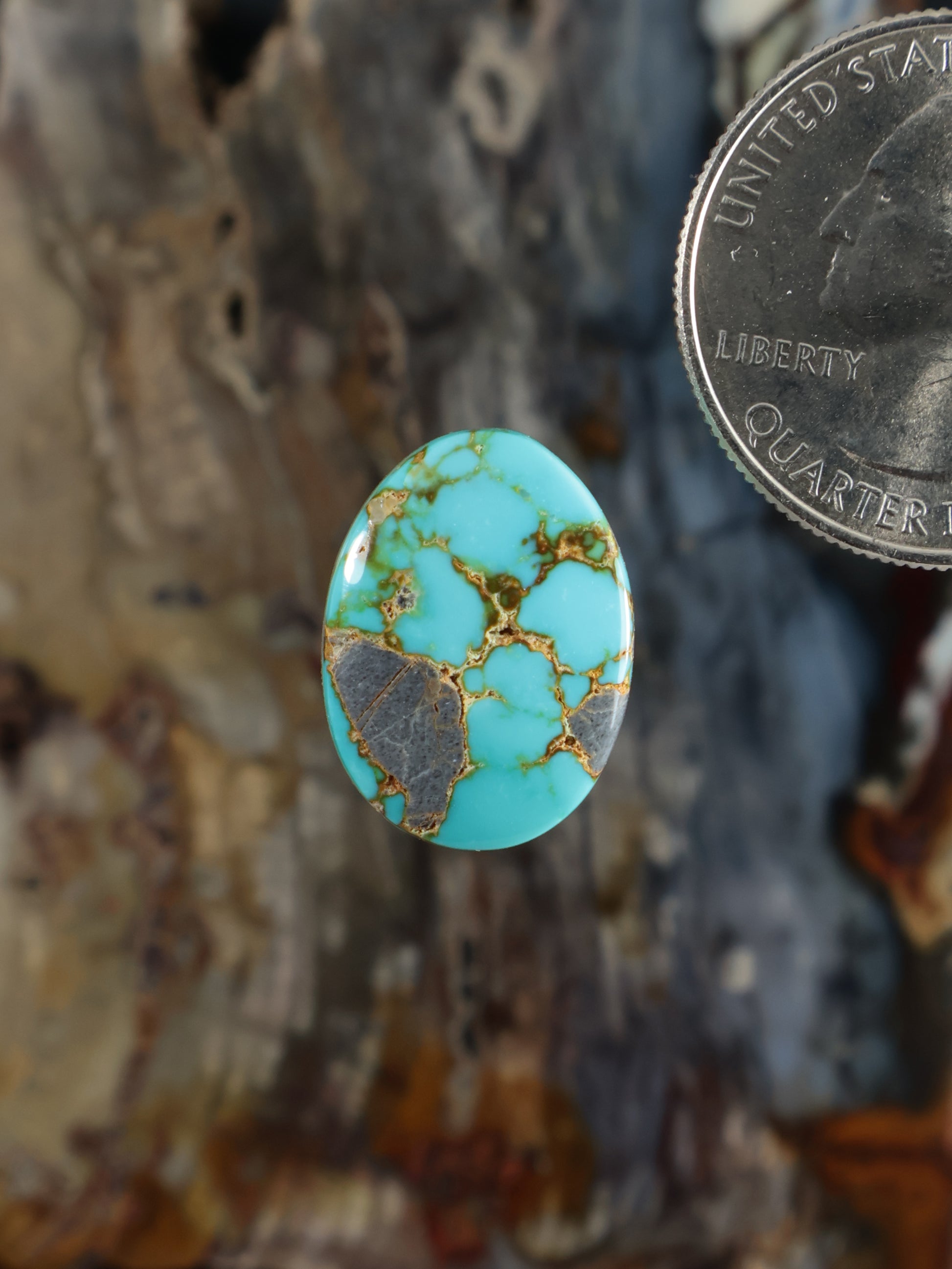 Oval turquoise cabochon gemstone with gold matrix veining