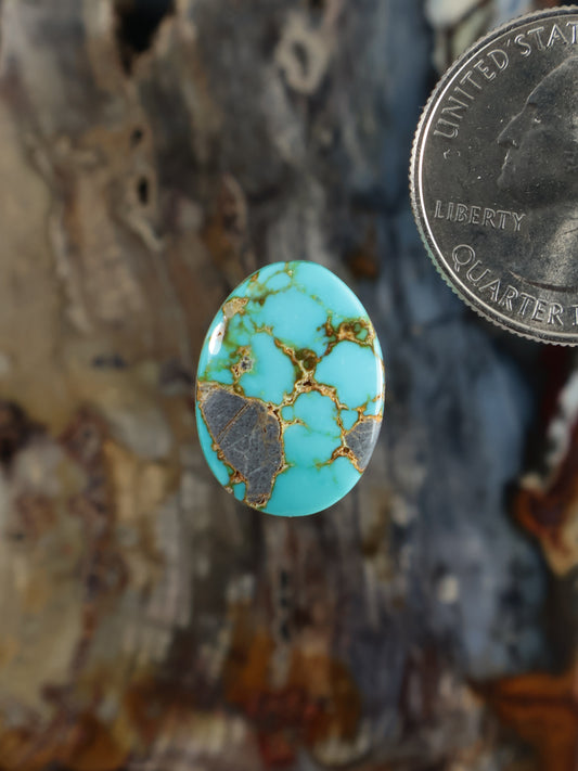 Oval turquoise cabochon gemstone with gold matrix veining