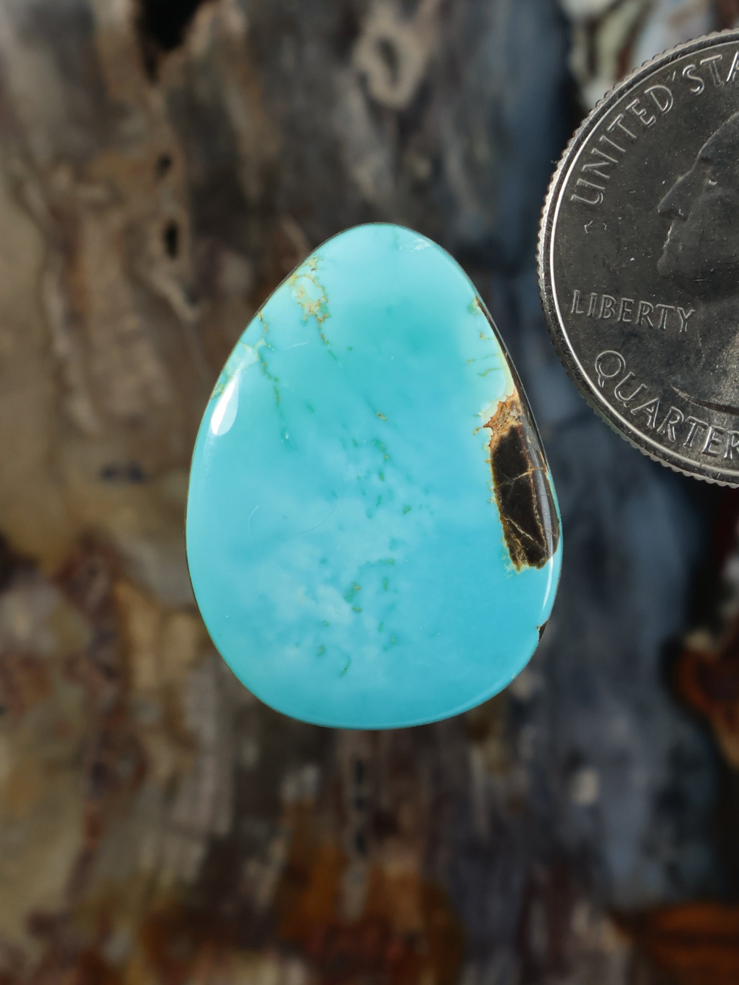 Turquoise cabochon gemstone in a teardrop shape, polished and smooth