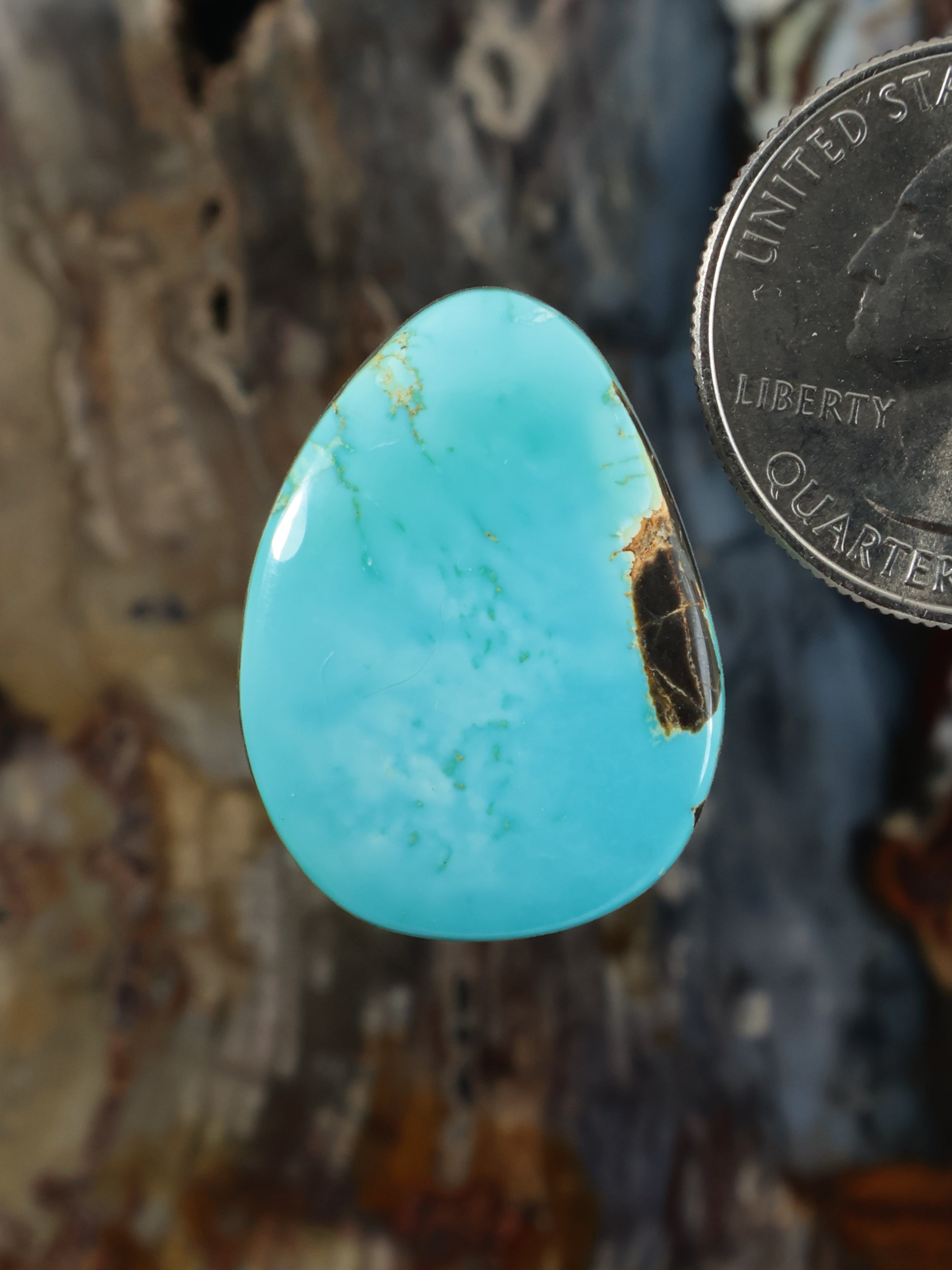Turquoise cabochon gemstone in a teardrop shape, polished and smooth