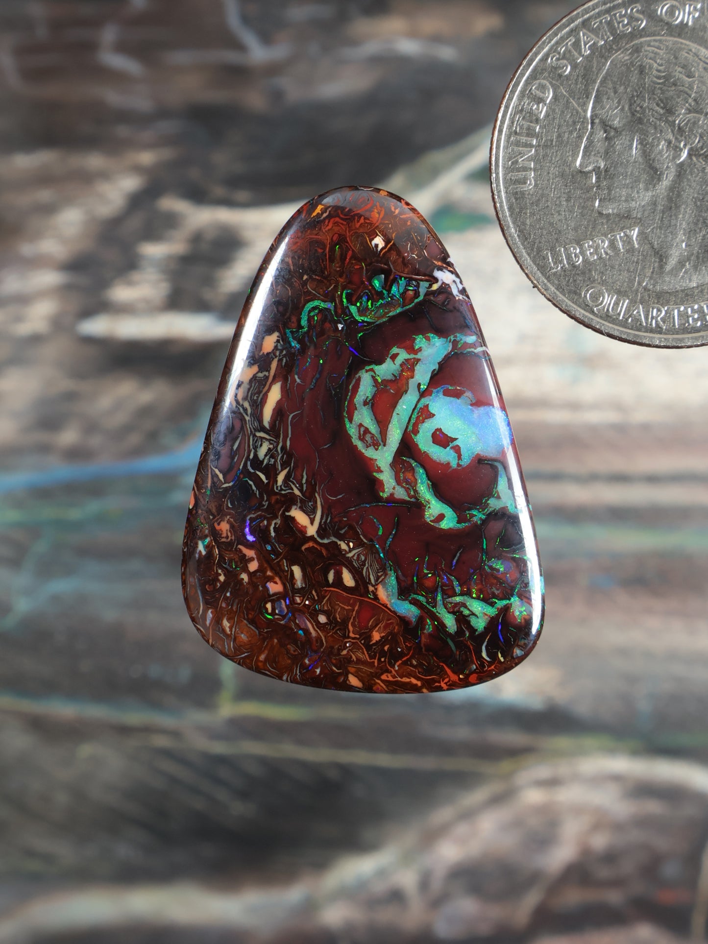 Yowah boulder opal cabochon, dark brown matrix with green-blue-red iridescence