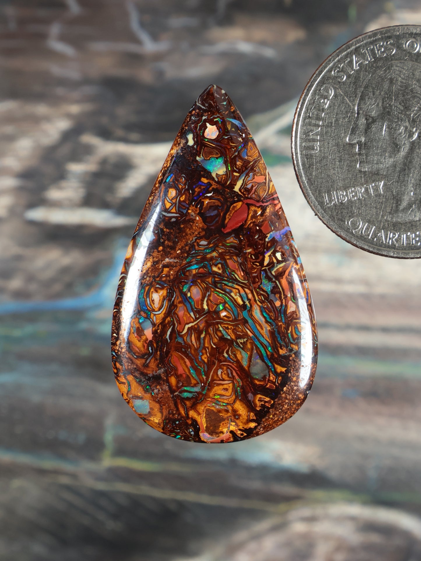 Yowah boulder opal cabochon, orange-brown teardrop with blue-green flashes