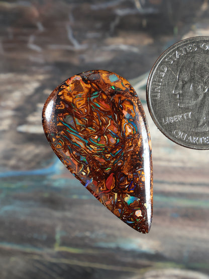 Yowah boulder opal cabochon, angled teardrop in orange-brown with blue-green striations