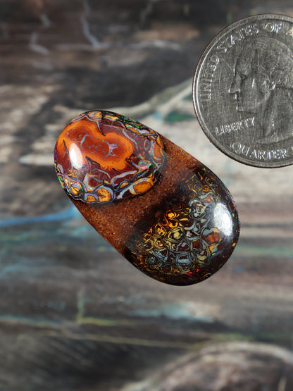Boulder opal cabochon, angled oval with orange-red swirls and blue-green accents