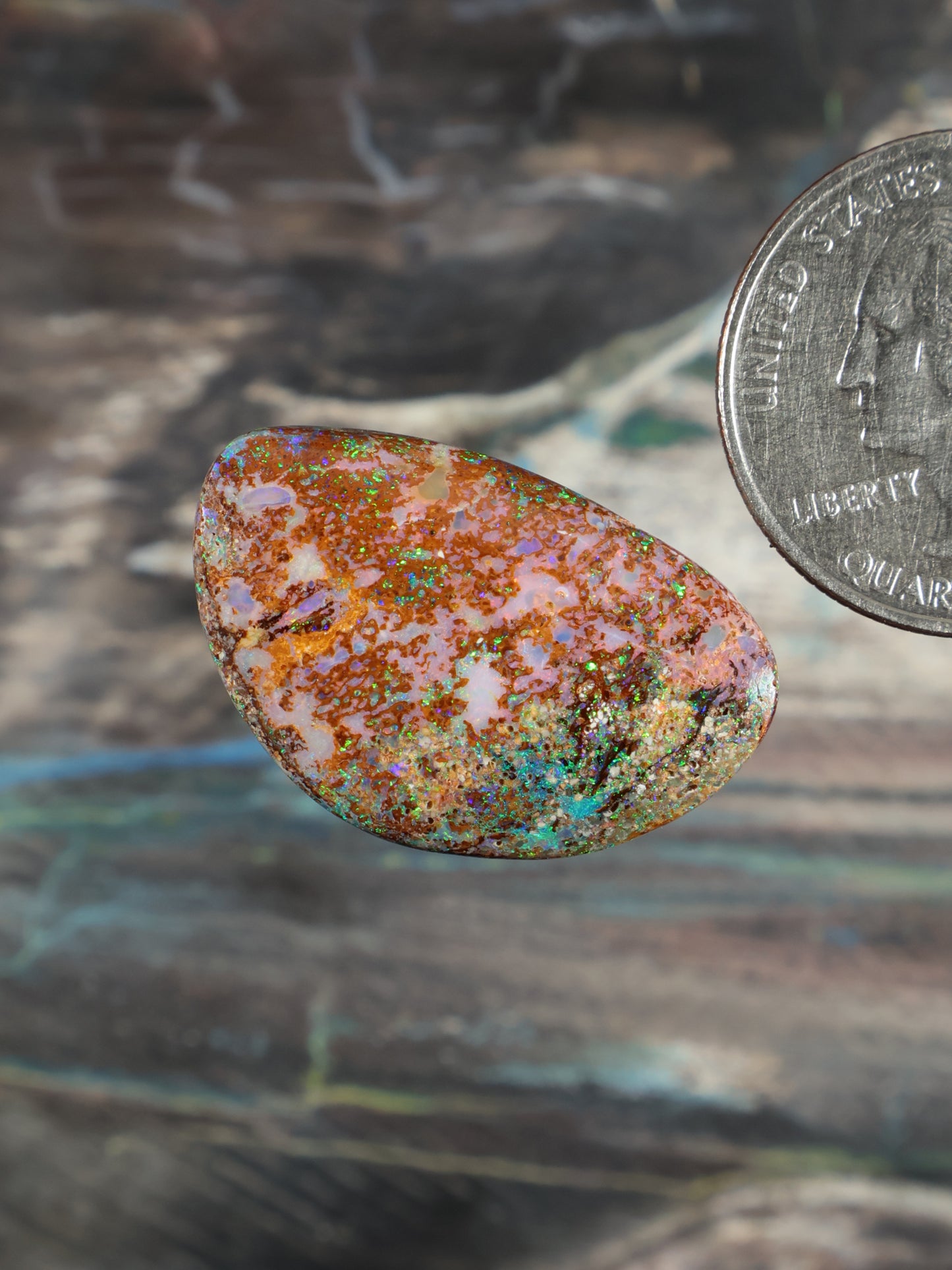 Boulder opal cabochon, rounded oval with orange, blue, green, and white color play