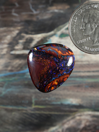 Yowah boulder opal cabochon, dark red and blue swirl pattern, polished teardrop