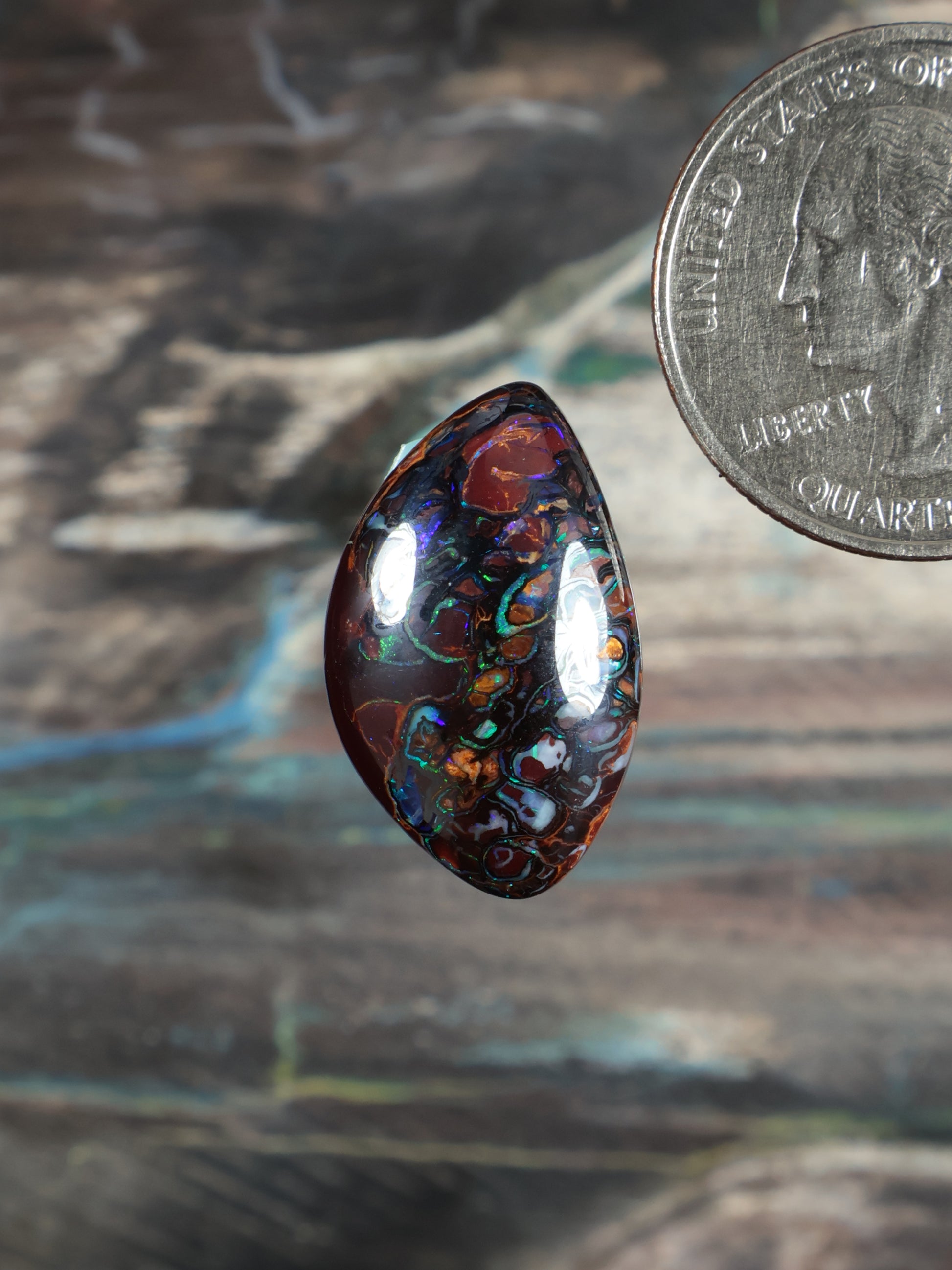 Dark brown boulder opal cabochon, teardrop shape with blue-green flashes