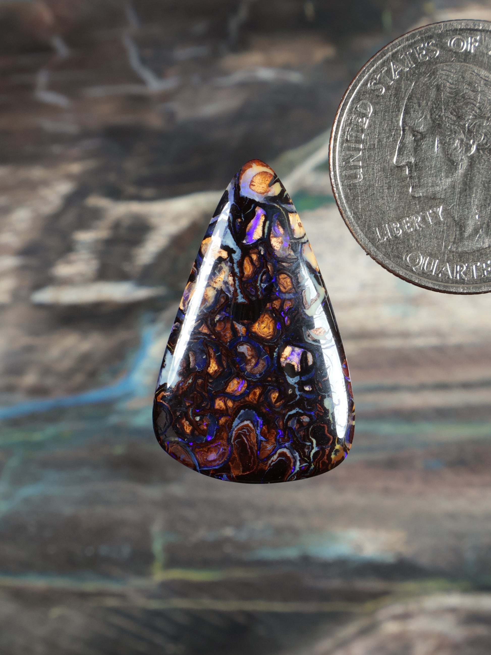 Boulder opal cabochon, iridescent blue-purple with orange patches, teardrop shape