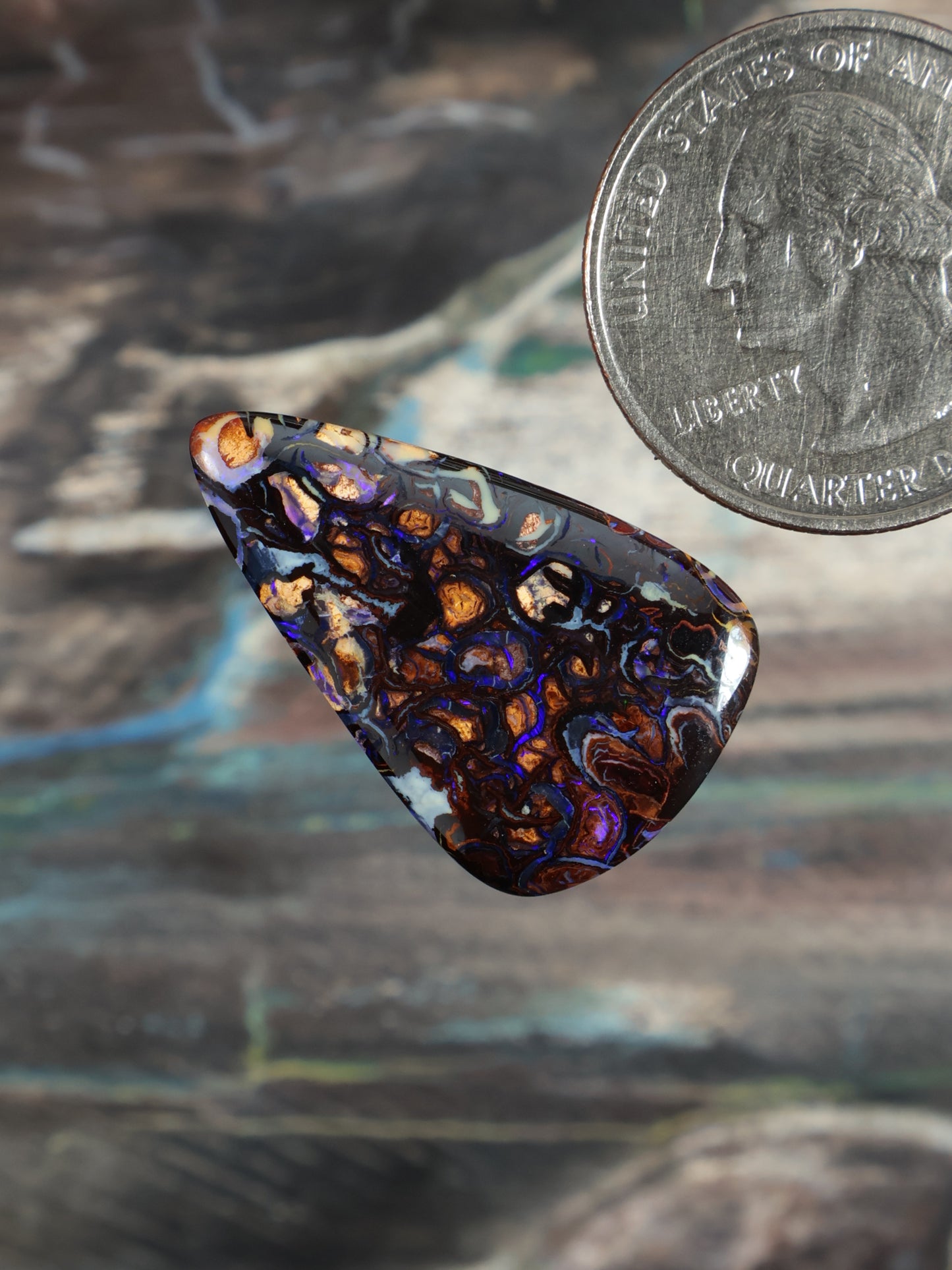 Boulder opal cabochon, iridescent blue-purple with orange flashes, angled triangular teardrop