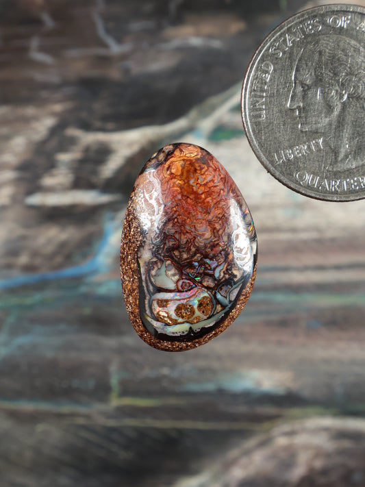 Boulder opal cabochon, oval; orange-brown stone with blue and teal swirls