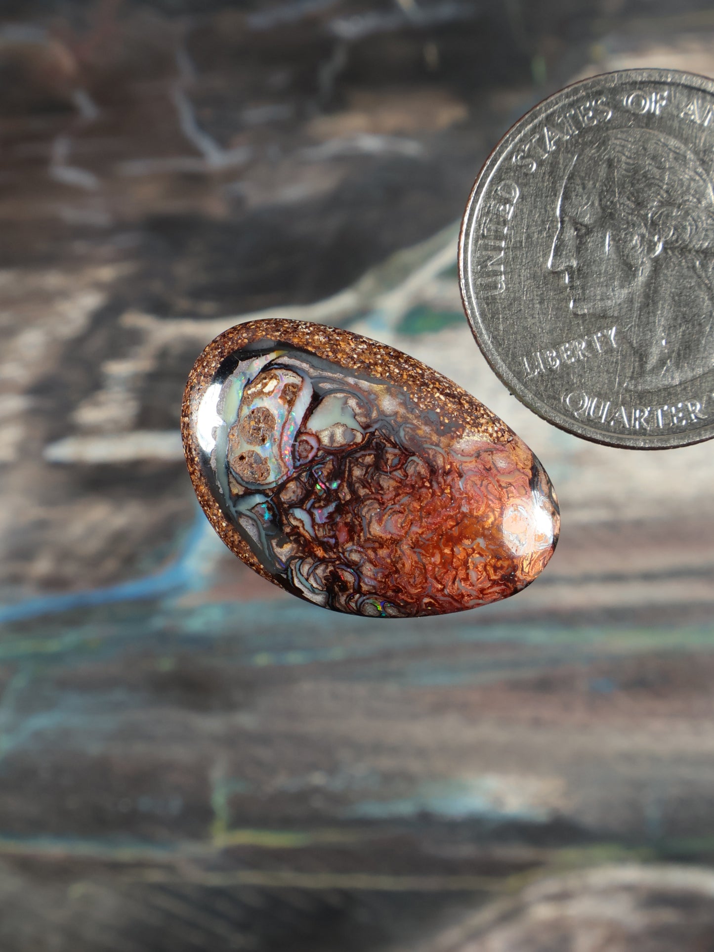 Boulder opal cabochon, oval; orange-brown base with white and blue marbling streaks