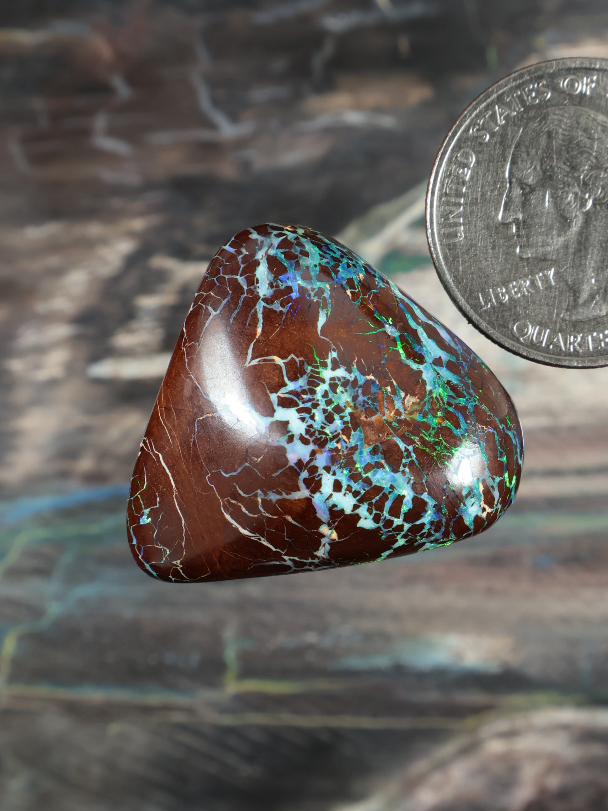 Opal boulder cabochon, brown with blue-green patchy matrix, teardrop shape.