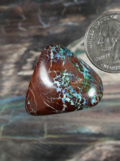 Opal boulder cabochon, brown with blue-green patchy matrix, teardrop shape.