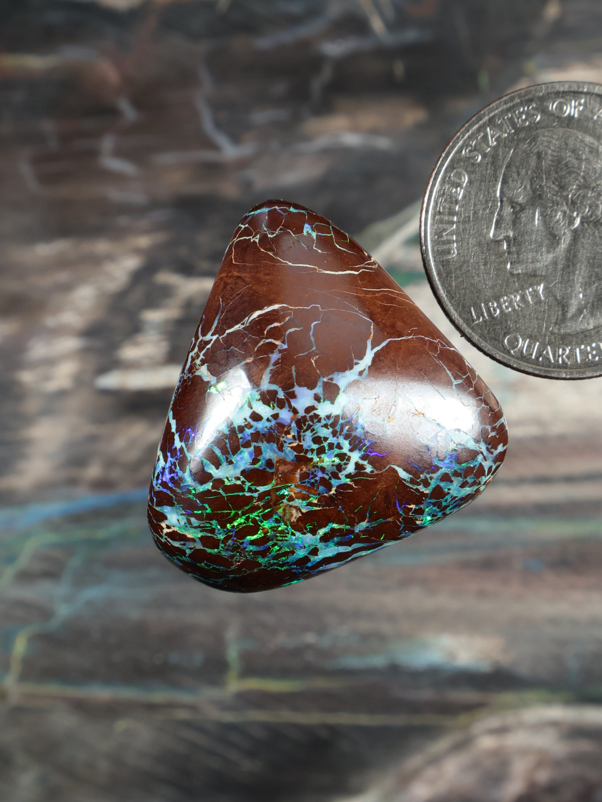 Opal boulder cabochon, brown with white fractures and teal-blue-green speckling, teardrop.