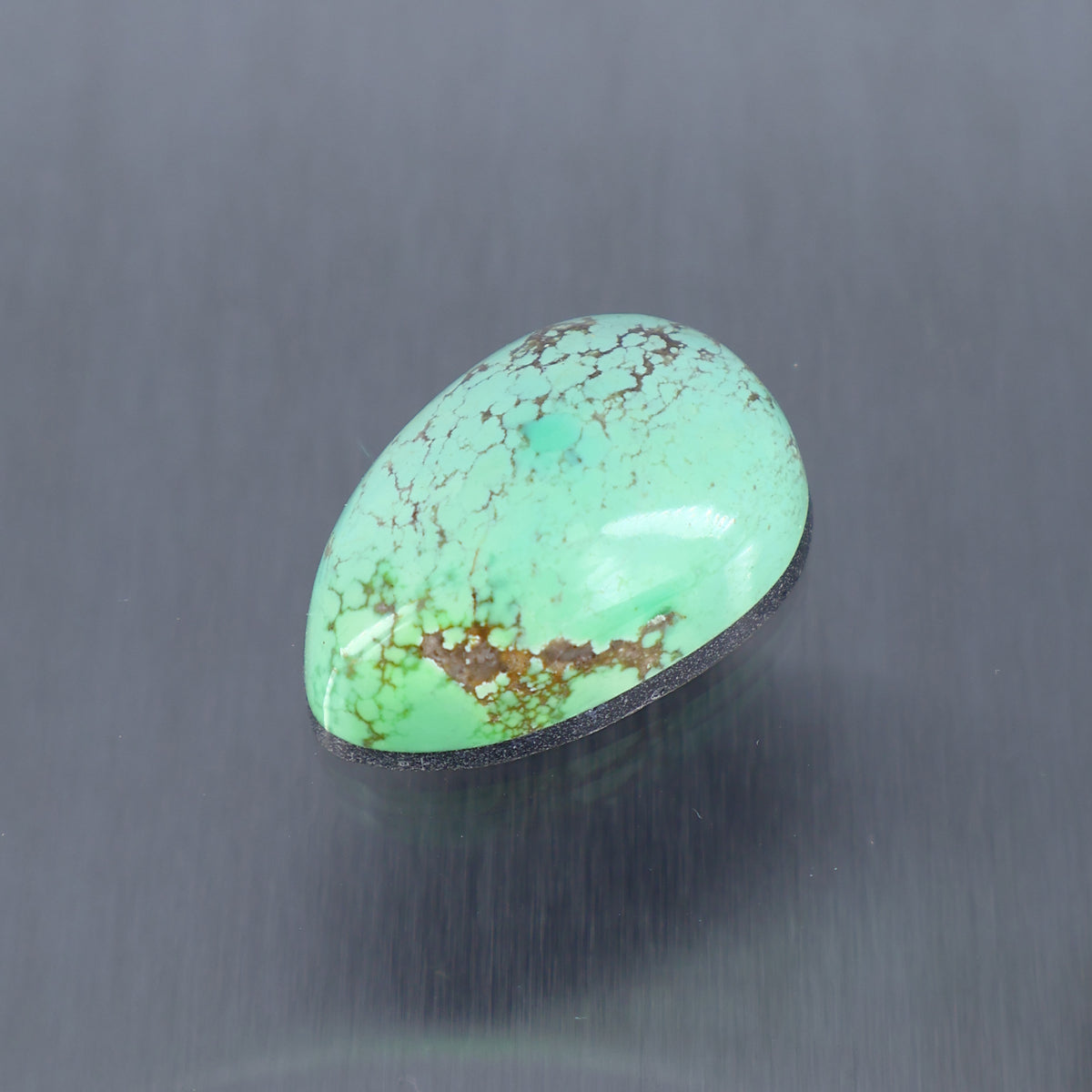 Turquoise cabochon gemstone, oval teardrop shape with veined pattern
