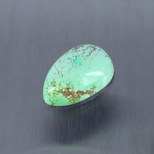 Turquoise cabochon gemstone, oval teardrop shape with veined pattern