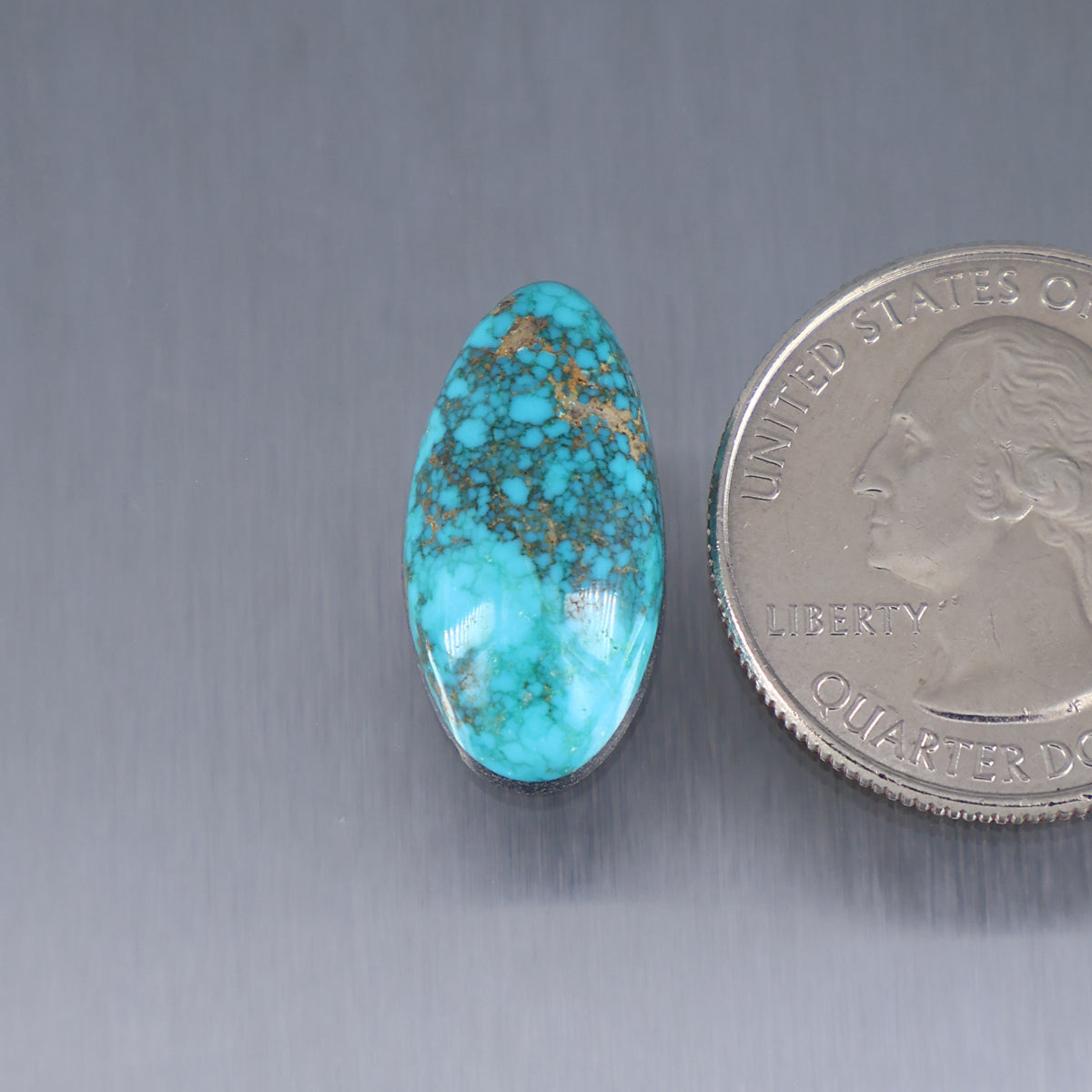 Oval turquoise cabochon gemstone with brown web matrix, glossy polished surface