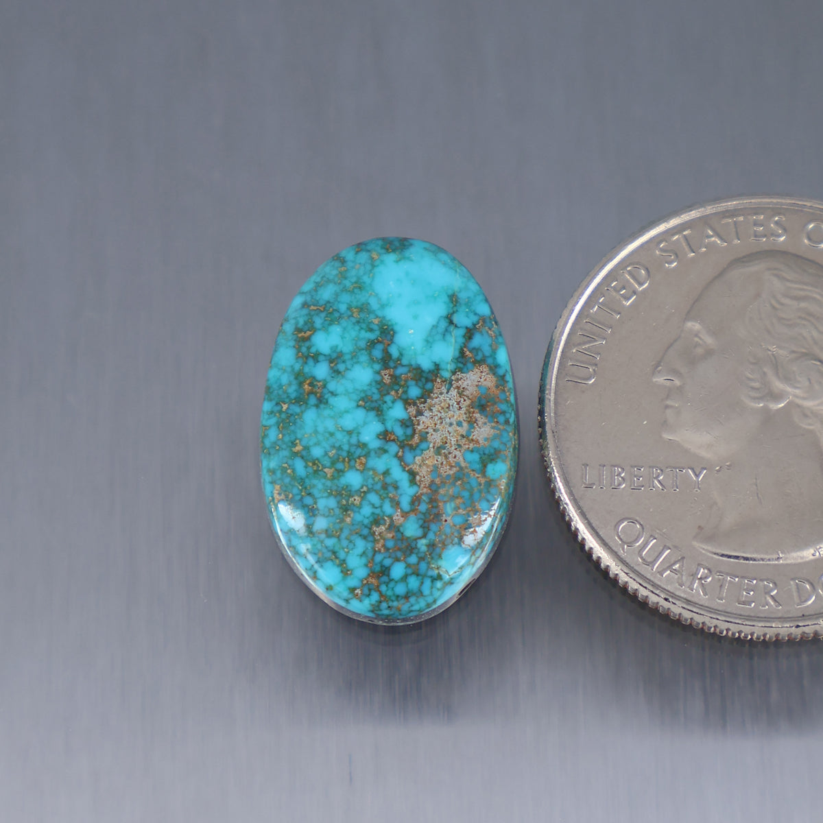 Turquoise cabochon gemstone in an oval bezel, blue with tan matrix veining