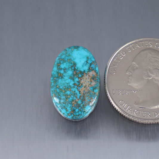 Turquoise cabochon gemstone in an oval bezel, blue with tan matrix veining