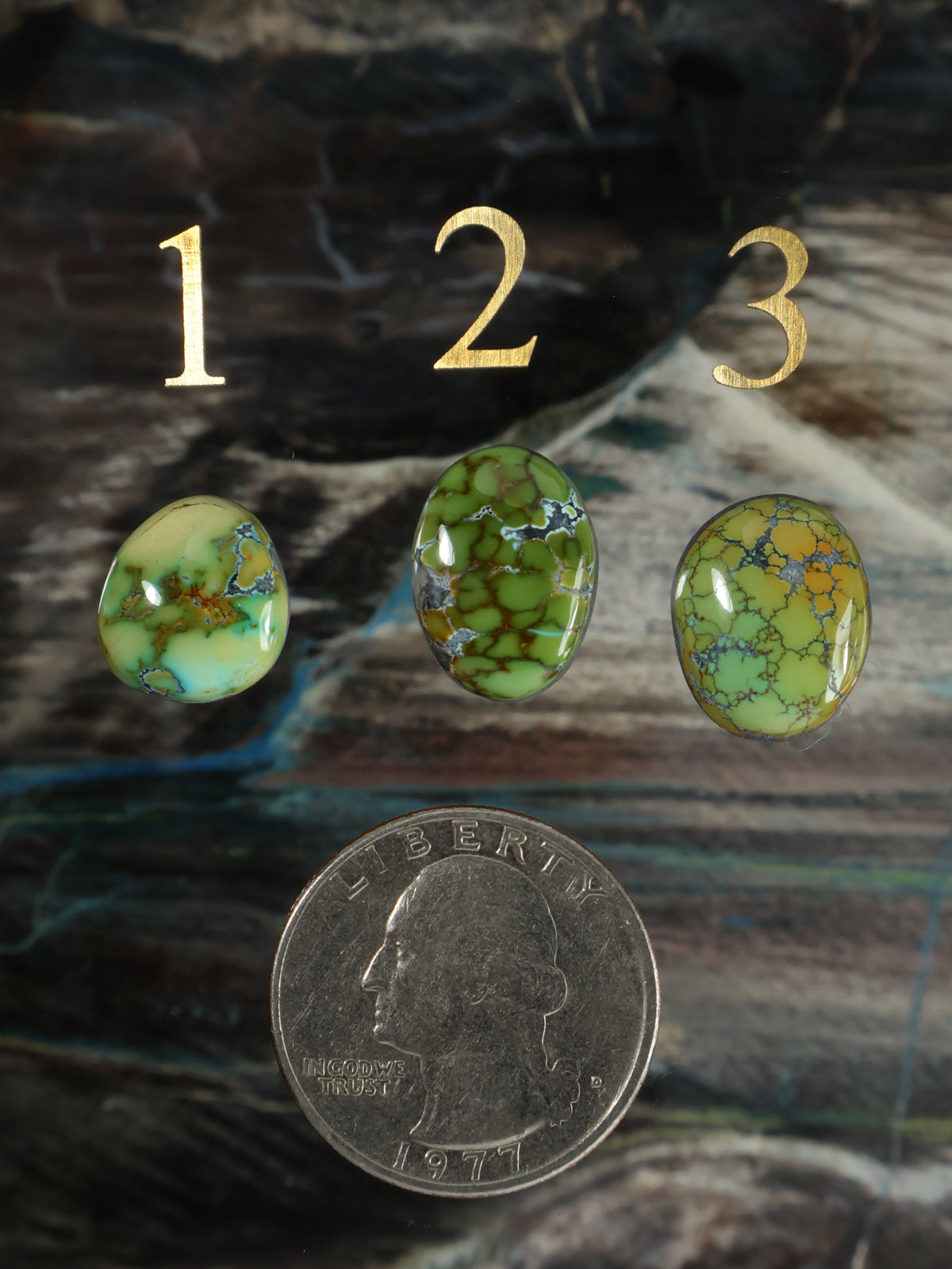 Three green oval gemstone cabochons with swirling veined pattern and polished surface