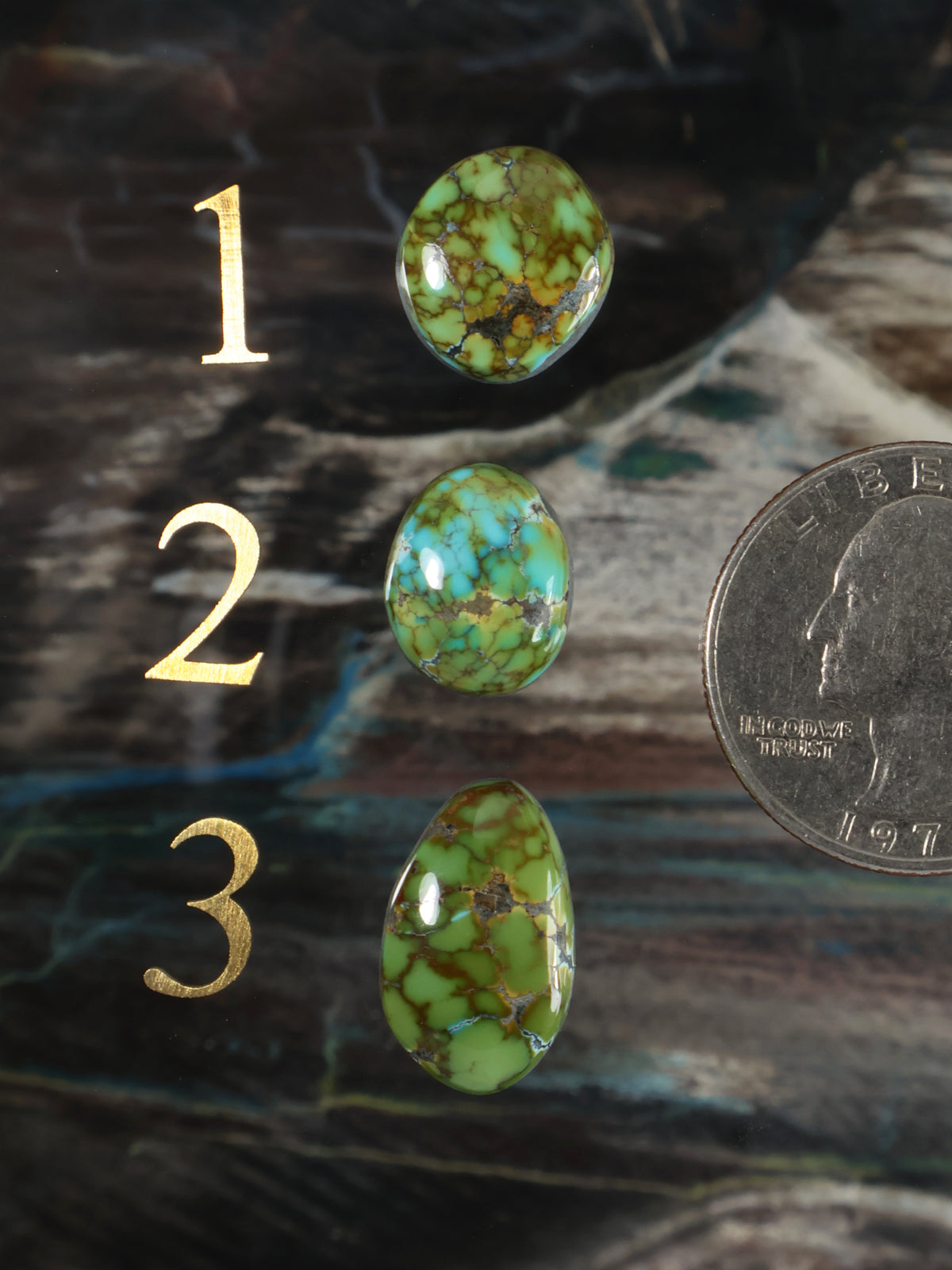 Set of three oval turquoise cabochon gemstones with green and gold veining.