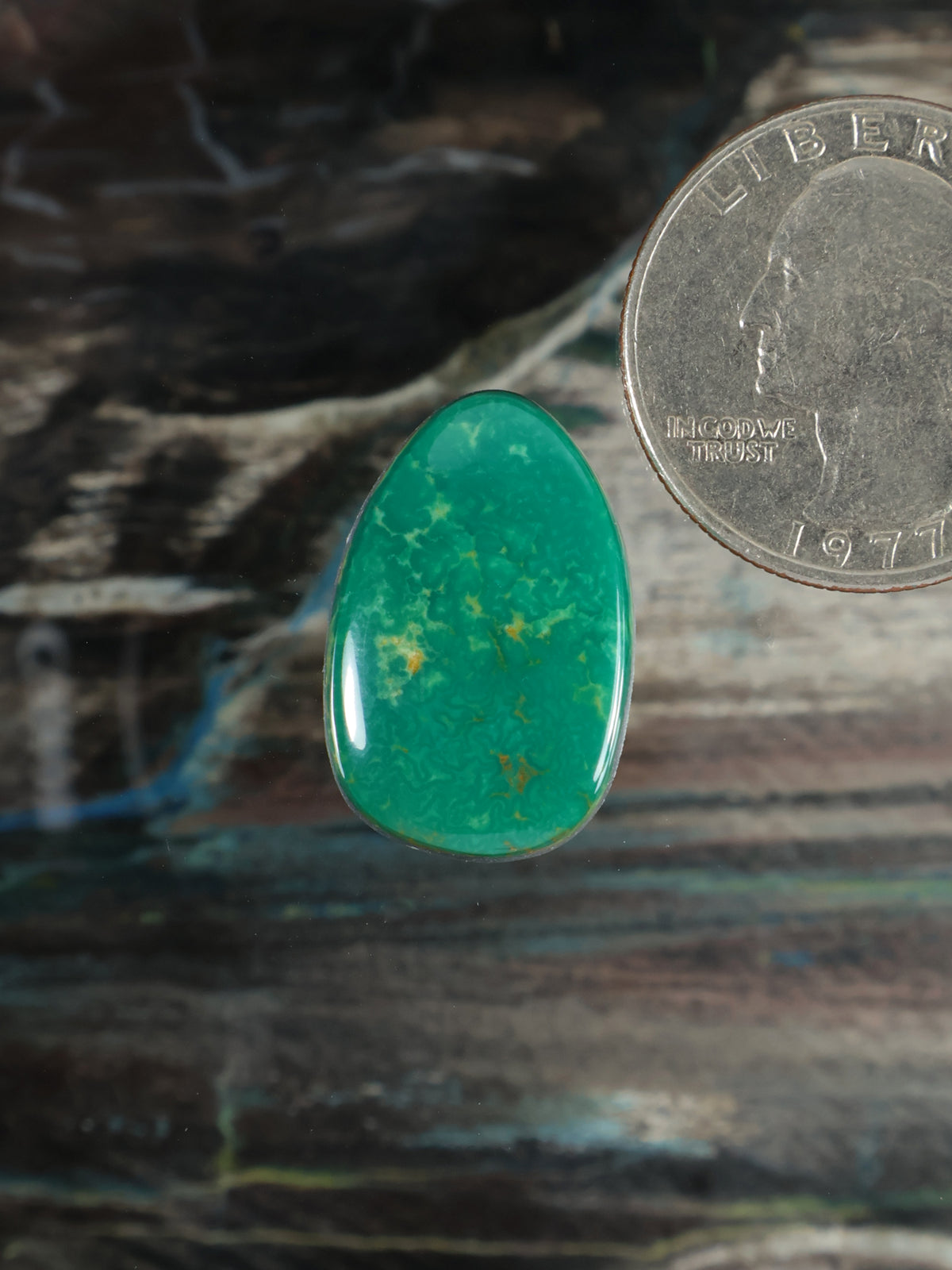 Green teardrop cabochon gemstone with glossy polished surface