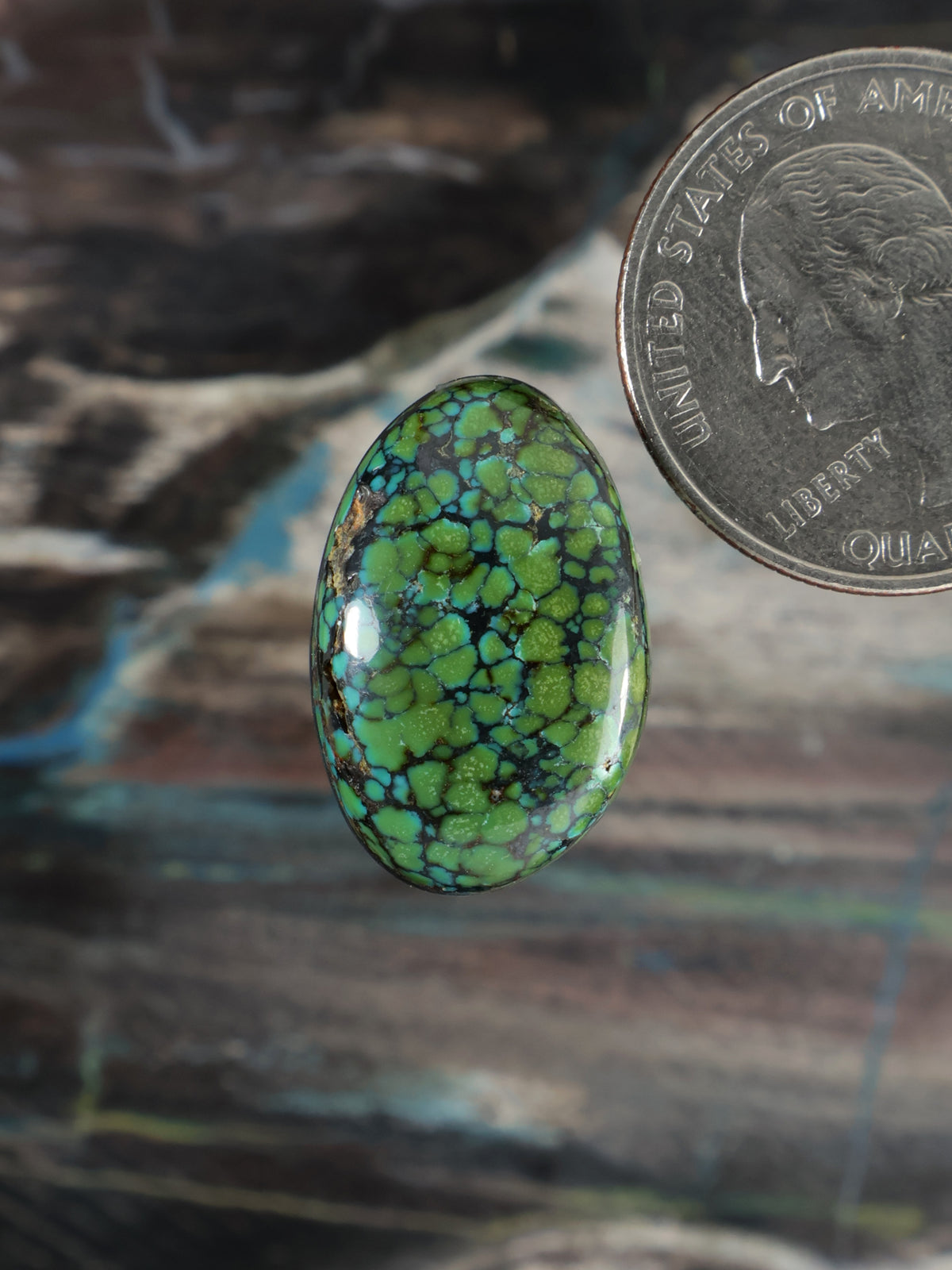 Green mosaic-pattern oval cabochon gemstone with black webbing