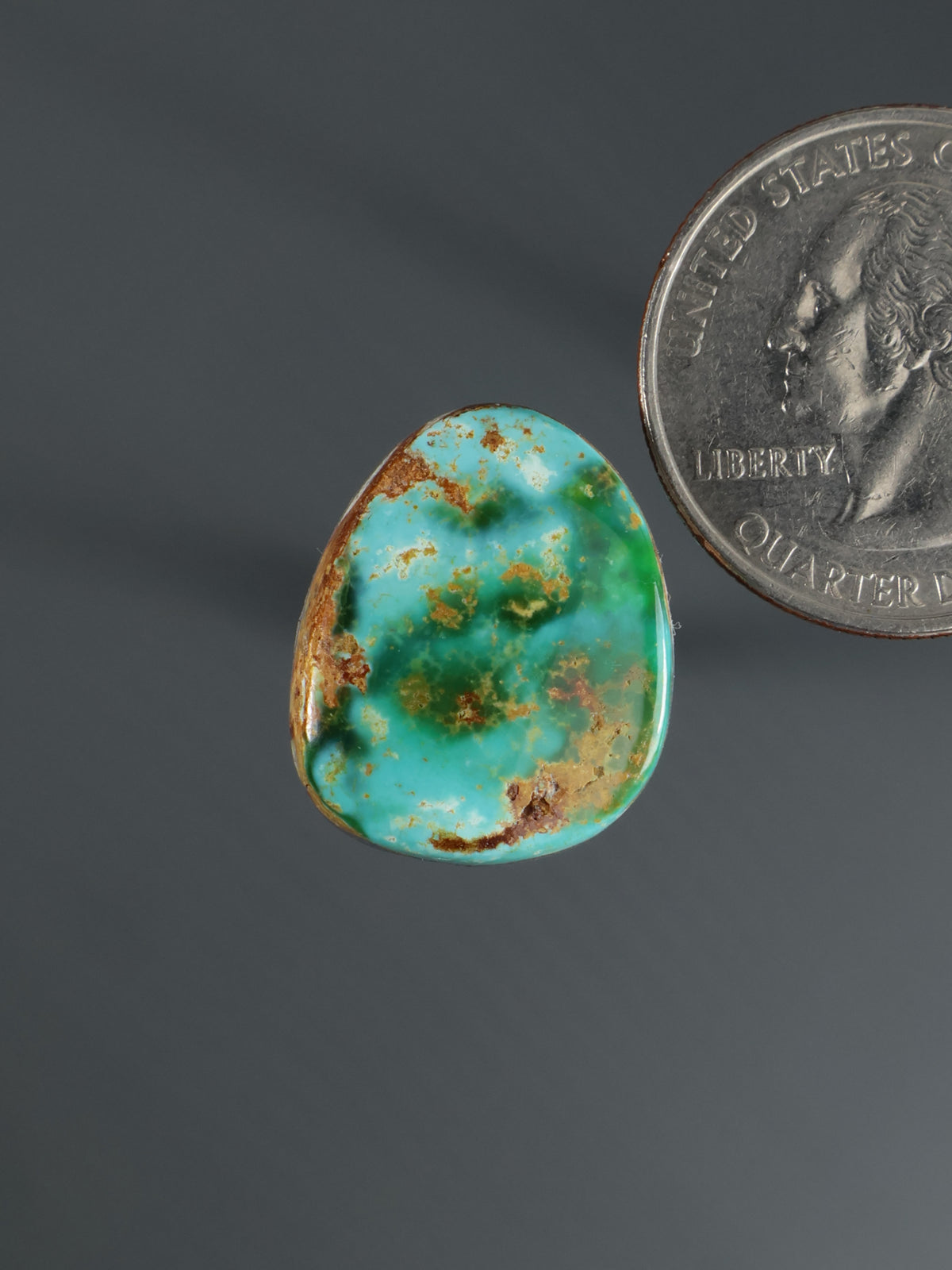 Turquoise cabochon gemstone with teardrop shape and brown matrix veining