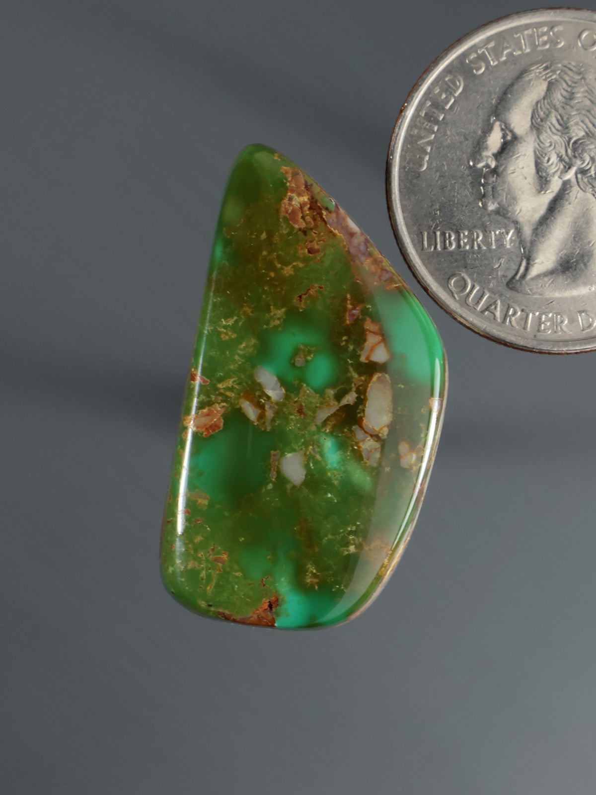 Green teardrop cabochon with brown speckled stone matrix