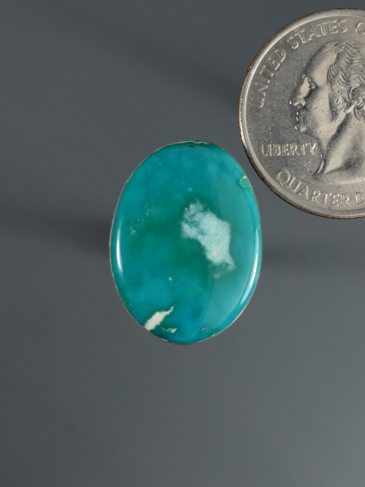 Turquoise oval cabochon gemstone with white veining, close-up