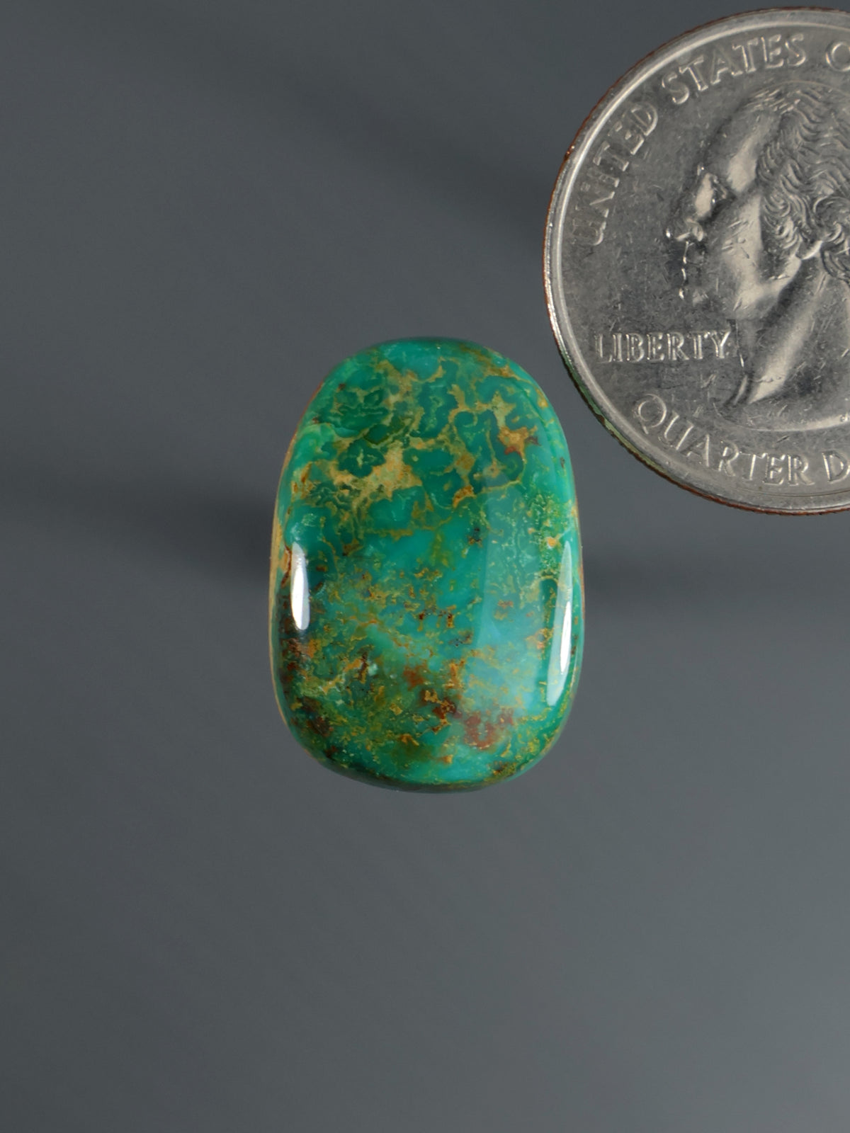 Oval green and blue cabochon gemstone with smooth polished surface