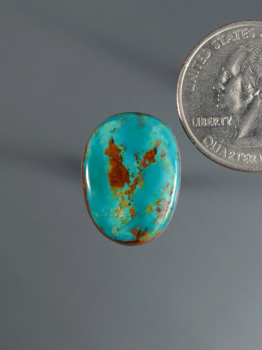 Oval turquoise cabochon with brown matrix veining, domed gemstone